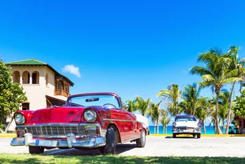Foto op Canvas Roter amerikanischer Cabriolet  Oldtimer und ein blau weisser Oldtimer parken am Strand von Varadero in Cuba - Serie Kuba Reportage © mabofoto@icloud.com