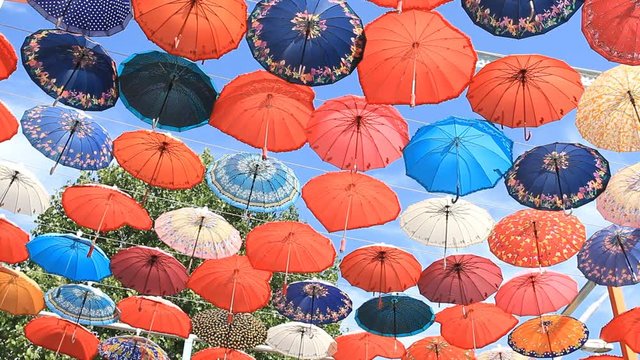 Decorative umbrellas hanging against the blue sky