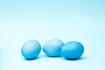 Painted easter eggs on blue background, monochrome view