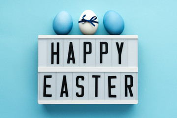 Wishing happy easter on blue background with color eggs