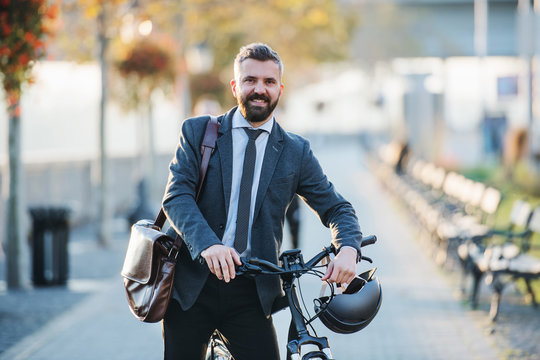 Businessman Commuter With Bicycle Walking Home From Work In City.