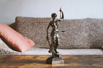 lady justice or justitia statue on table in living room - landlord and tenant law or right of...