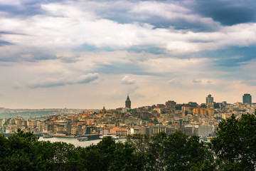 Fototapeta na wymiar Cityscape of Istanbul with Galata tower under dramatic cloudy sky, Turkey