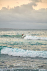 Surfer surfing a wave on a cloudy day