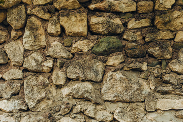 Old beige stone wall background texture close up