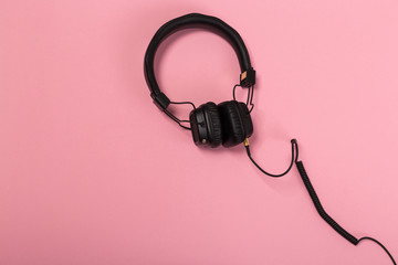 black headphones on pastel background.