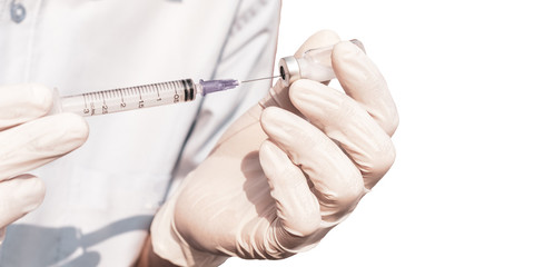 Doctor hand holding vials medication and injection needle isolated on white background. Medical doctor picking up medication into syringe.