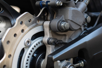 Closeup detail of sport racing motorcycle wheel and ABS brakes system with aluminium swingarm 220 mm rear disc 1 piston caliper stopping power ABS fitted as standard.