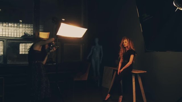 Photographer shooting a female photo model in a studio