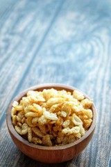 Close up of dried rice snack on wooden bowl. 