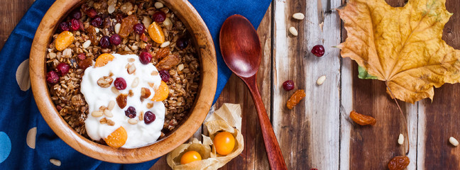 Homemade granola with nuts, cranberries and yogurt for breakfast