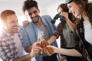Small group of young people hang out at the house party, friends having fun