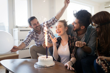 Group of friends enjoying and celebrating birthday and partying
