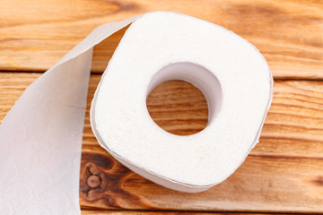 Toilet paper roll close up on wooden background
