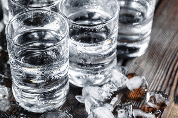Vodka in shot glasses on rustic wood background