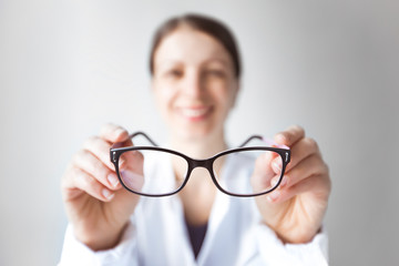Woman doctor ophthalmologist is holding glasses. The concept of vision problems. Optics for eyes.