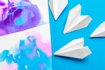 white paper airplane on a color block paper background