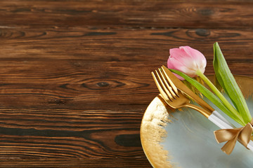 Table setting arrangement in minimal style with easter spring holiday attributes, fork, knife and napkin. Background, copy space, close up, flat lay, top view.