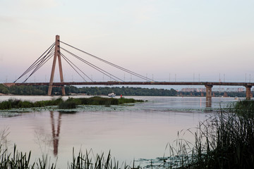 Fototapeta na wymiar Large bridge over the Dnipro river in Kyiv Ukraine in sunset