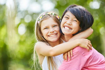 Two girlfriends hug each other happily