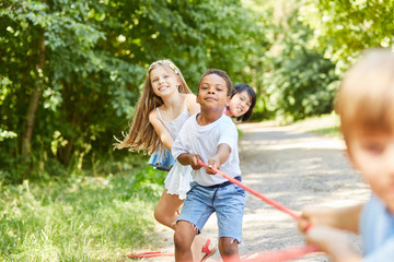 Fototapeta premium Multicultural children team in tug-of-war