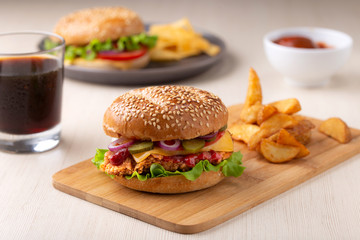 Burger with sliced pickle, onion and fried potatoes	