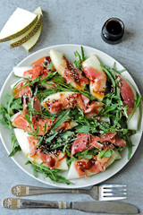 Salad with arugula, melon and prosciutto. Keto diet. Paleo diet. Pegan diet. The concept of a beautiful and delicious diet food.