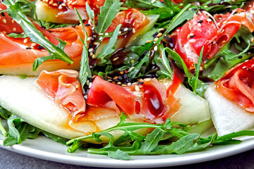 Salad with arugula, melon and prosciutto. Keto diet. Paleo diet. Pegan diet. The concept of a beautiful and delicious diet food.