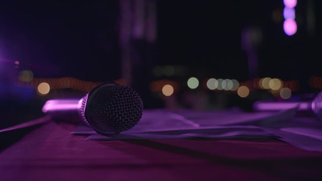 Wireless event microphone at night stage with color spotlight
