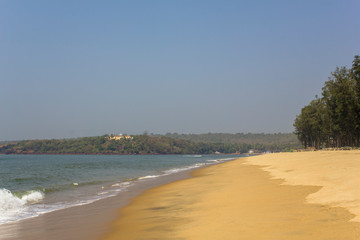 yellow sandy beach in the background of the sea bay and green jungle