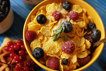 Healthy breakfast. Corn flakes with raspberries and blueberries, granola with yogurt and berries, wafers and milk.