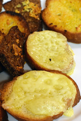 Fried bread slices with melted cheese. Vertical close up image.