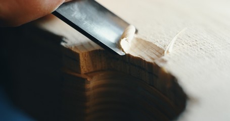 Macro close up of professional master artisan luthier painstaking detailed work on wood violin in a workshop.