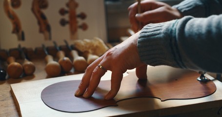 Portrait of master artisan luthier working on creation of handmade violin  in a workshop.  © Kitreel