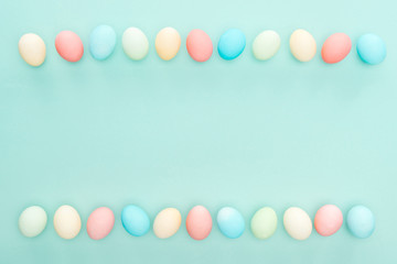 top view of traditional pastel easter eggs in rows isolated on blue