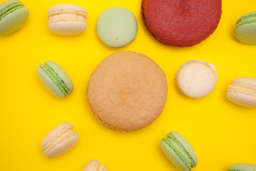 Top view of delicious french macaroons over yellow background