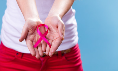 Woman with breast cancer awareness ribbon on hands