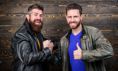 Handshake symbol of successful deal. Have agreed. Brutal bearded men wear leather jackets shaking...