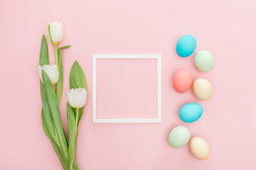 top view of tulip flowers and easter eggs with frame isolated on pink