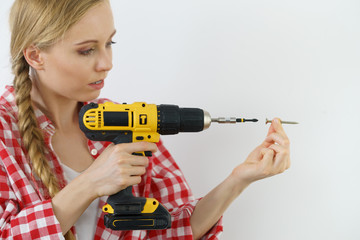 Woman drilling in wall