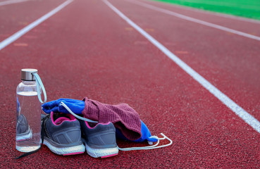 Rucksack and water bottle on athletic track