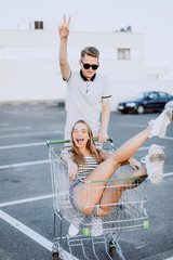 Loving hipster freedom positive couple having fun near supermarket after shopping. Happiness, love,...