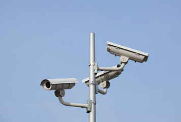 Surveillance system of three cameras located on a pole in the open. Threat to privacy and personal data protection. Security surveillance on the streets of the city and industrial objects