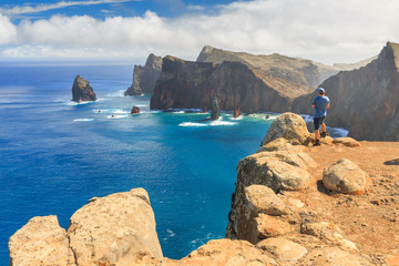 Tourist on the cliffs in the beautiful landscape of the east coast of the island Madeira at Ponta...