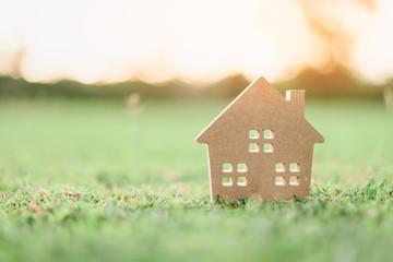 Copy space of home and life concept. Small model home on green grass with sunlight abstract...