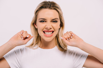 beautiful woman biting dental floss and looking at camera isolated on white