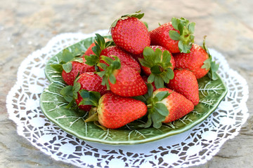 strawberries on green plate and light background.