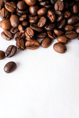 Close up dark roasted coffee beans on white cotton fabric and white filter paper  background in natural light 