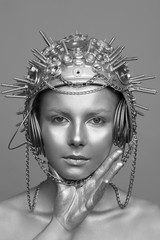 Futuristic woman in metal helmet with screws, nuts and chains