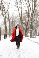Beautiful young woman walking outdoors in snow winter.